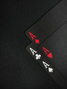 Close-up of four aces on a black background, ideal for casino-themed content.